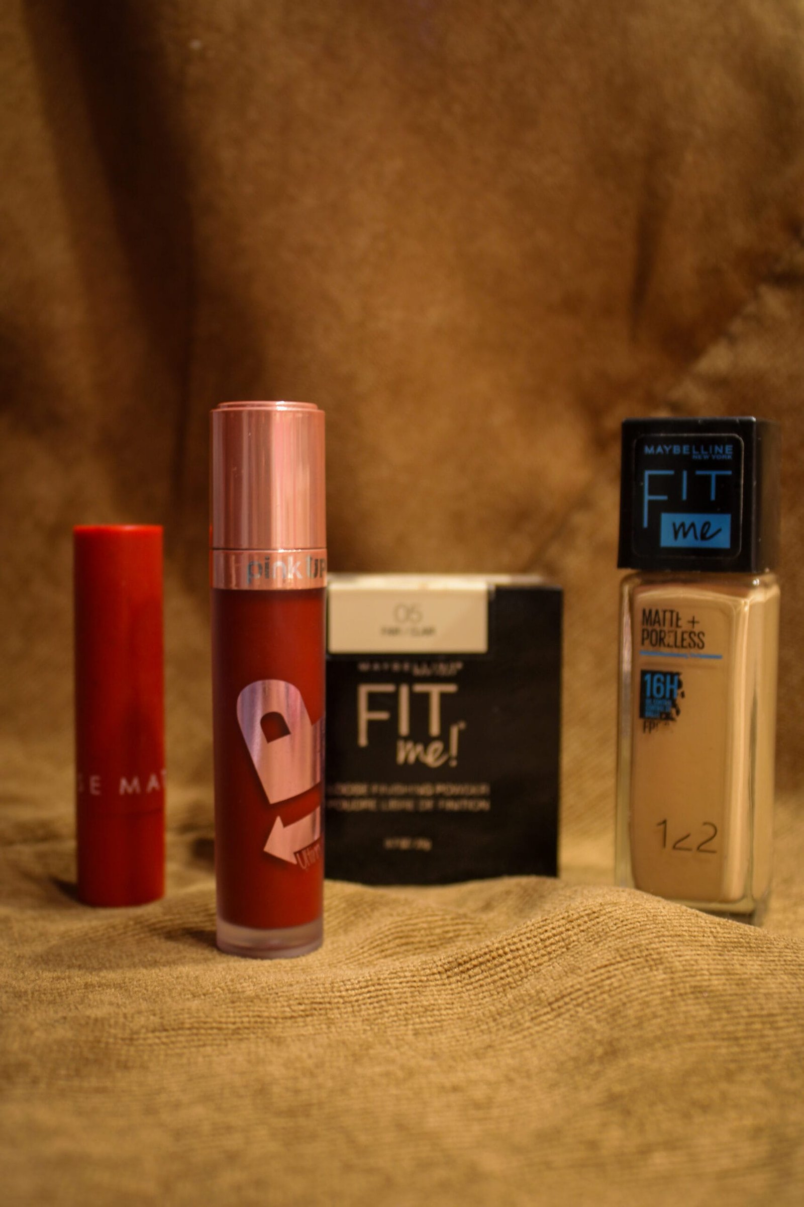 Base de maquillaje en envase de vidrio de larga duración, polvo suelto traslucido, labial mate rojo, lip gloss.