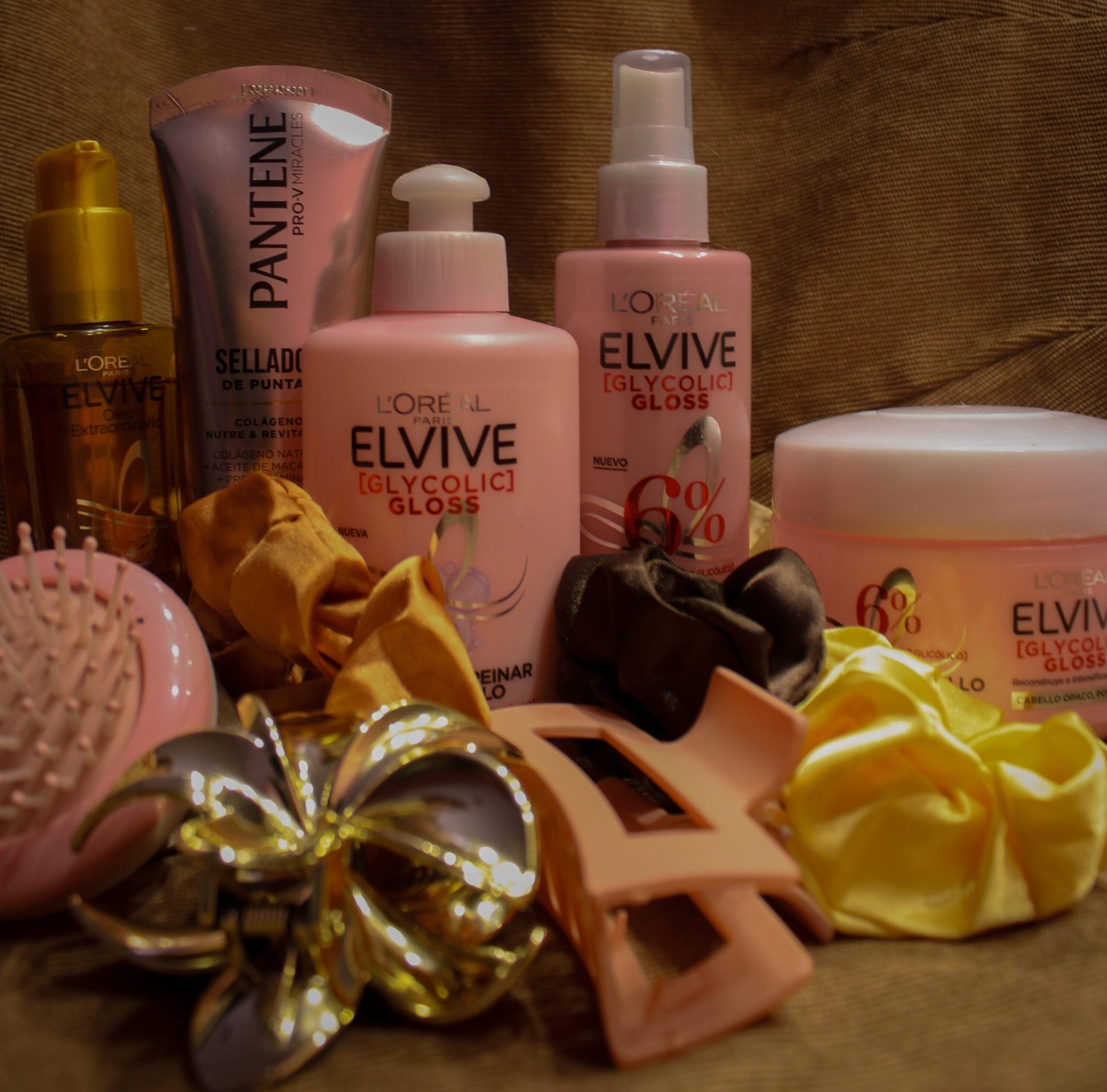 productos para el cabello de envase rosa, usado para mantenerlo suave y brillo, accesorios para el cabello