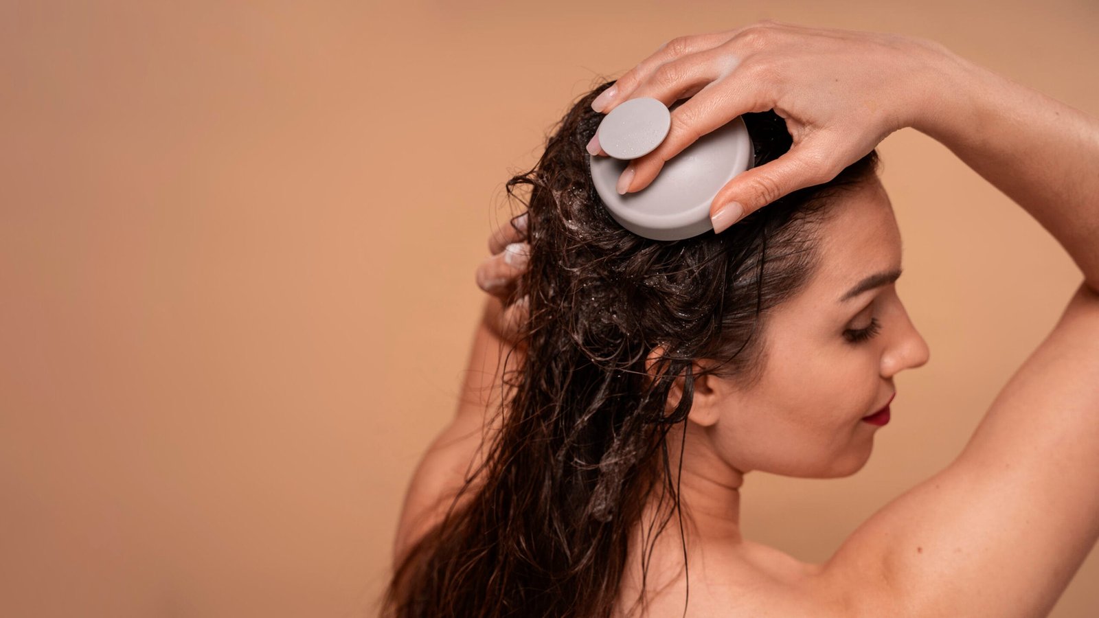 chica de piel trigueña lavando su cabello y dándole pequeños masajes a su cuero cabelludo para el crecimiento del cabello